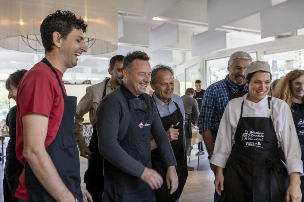 The company team has fun together during the "Mani in Pasta" culinary team-building activity
