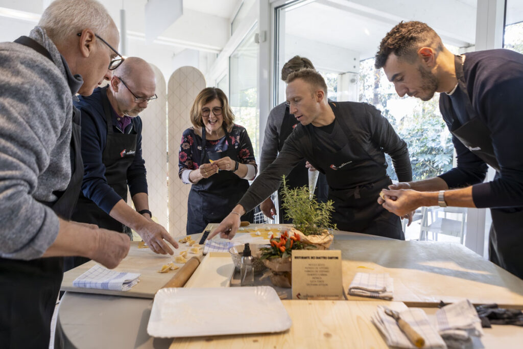 Team aziendale prepara insieme i tortellini durante il team building Mani in Pasta