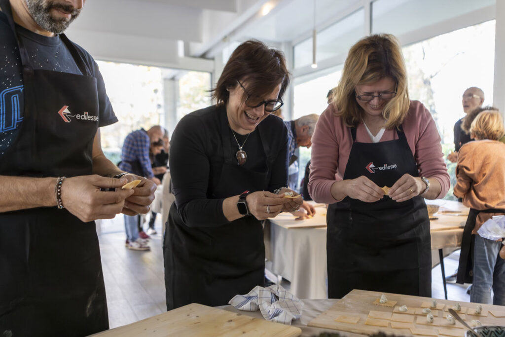 Participants stuff and seal the tortelli by hand during the "Mani in Pasta" team-building event
