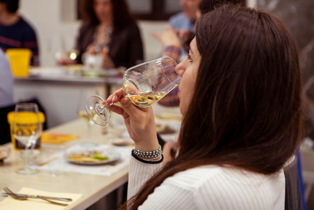 A participant tastes a white wine during a sensory tasting team-building event